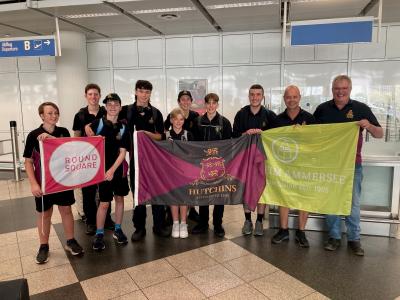 Schülergruppe mit Fahnen am Flughafen