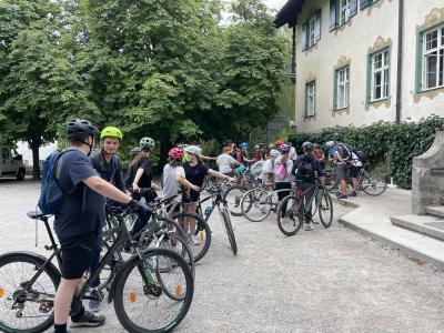 eine Menge Fahrräder mit Radfahrern vor dem Haupthaus des Landheim Ammersee