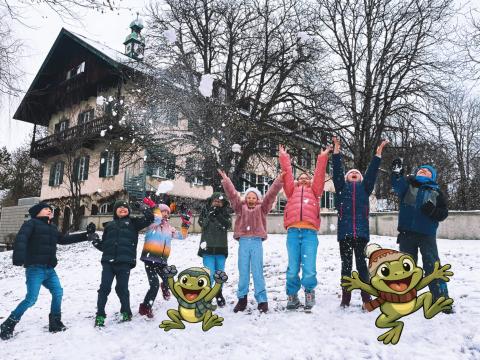 im Schnee spielende Kinder mit gezeichneten Fröschen
