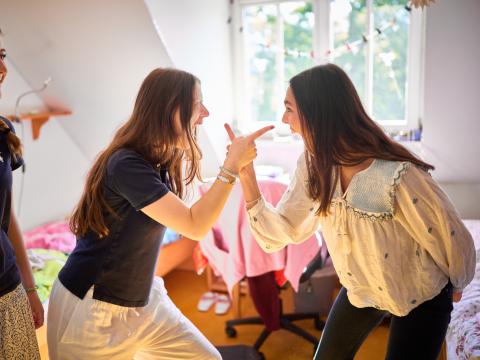Landheim Ammersee, zwei gestikulierende Mädchen im Zimmer