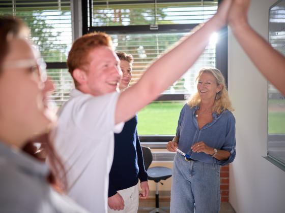 Schulklase an Tafel mit Lehrerin
