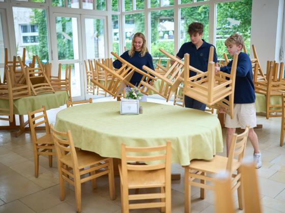 Landheim Ammersee, Schülergruppe stellt Stühle im Speisesaal auf